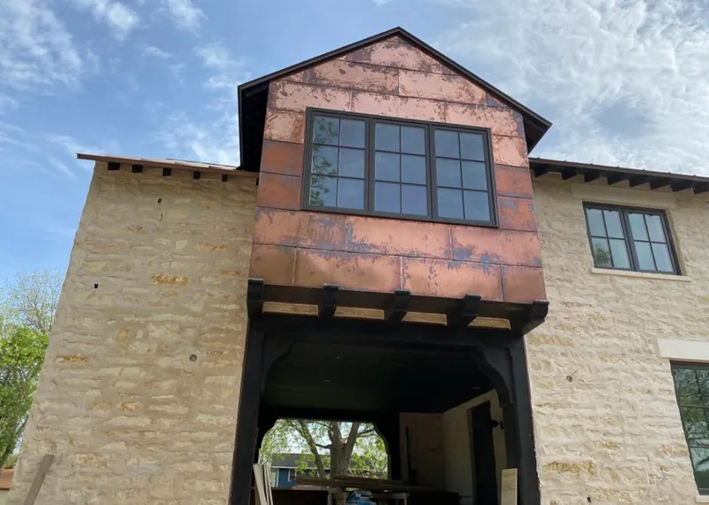 Copper metal panel facade on a stone building for Skylight Installation in Dunlap