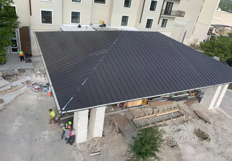 Metal roofing installation team working on a commercial building in Dunlap